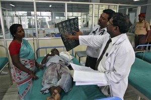 Doctors examine a MRI scan of a patient lying on a bed inside a ward at RGGGH in Chennai