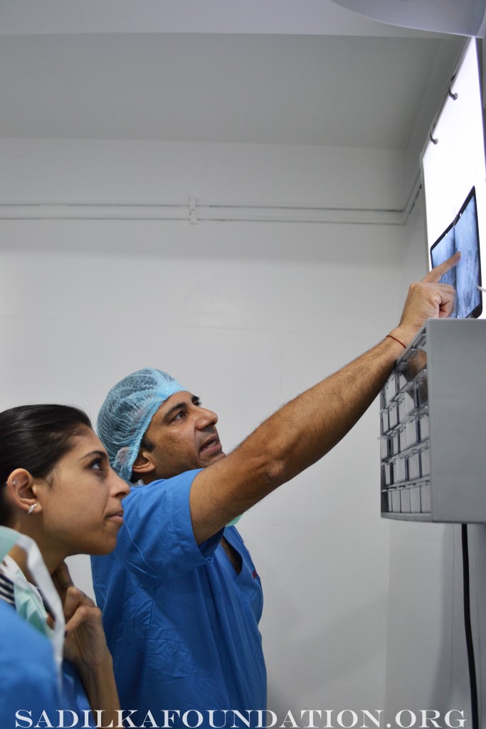 Dr. Gupta studies the Xray before surgery and shows Sarina the exact location of kidney stone.