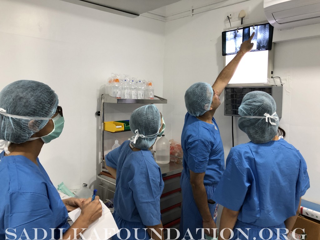 Dr. Gupta shows Kasmira and other volunteers how to read various X-rays.